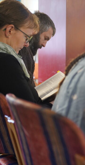 Gemeindemitglieder lesen gemeinsam in der Bibel