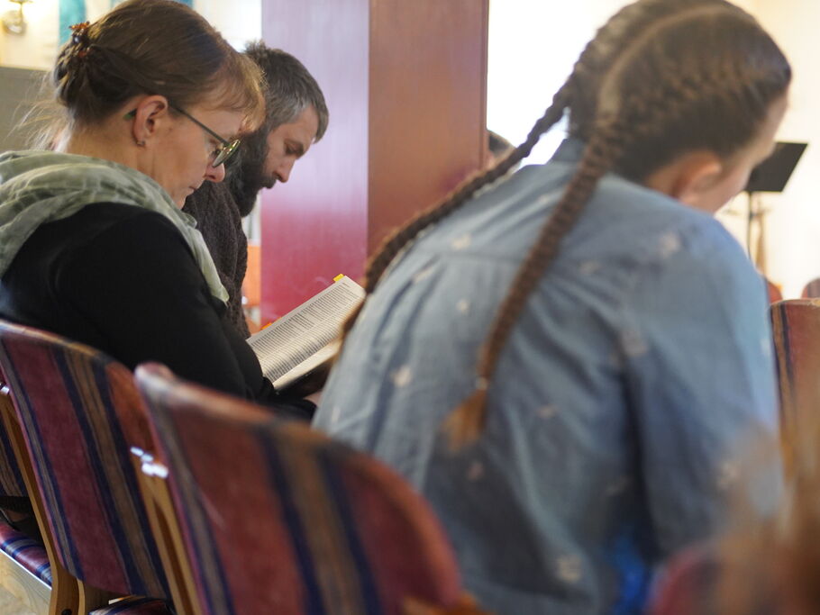 Gemeindemitglieder lesen gemeinsam in der Bibel