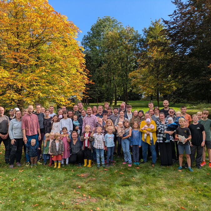 Die Gemeinde beim Gruppenfoto unter Herbstbäumen